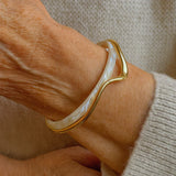Elegante pulseira aberta com esmalte branco e dourado